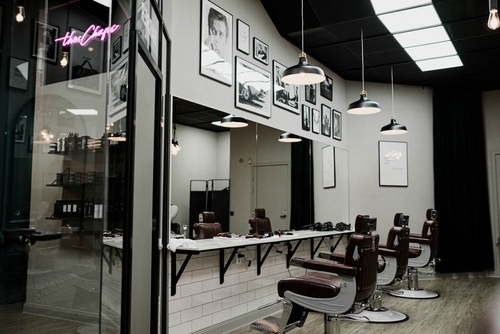 Modern barbershop interiör i Stockholm - elegant svart-vit design med klassiska barberarstolar, spegelvägg och industriella lampor
